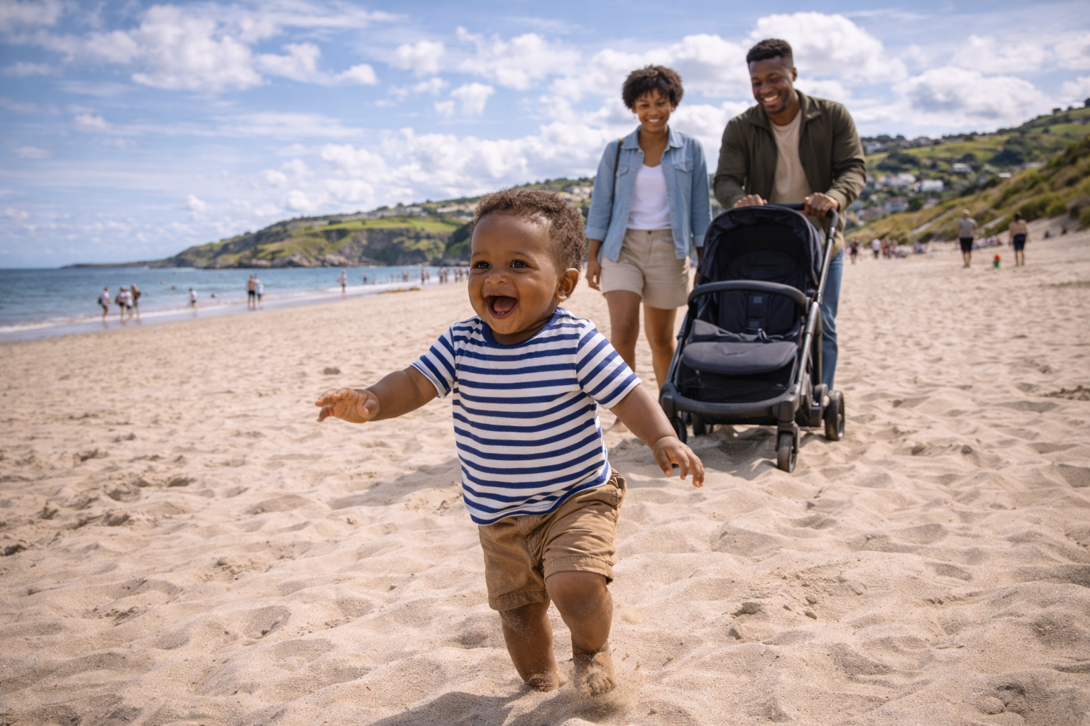 A toddler around 18 months running ahead on a flat UK beach with parents following behind with a stroller, bright summer day with joyful chaotic energy